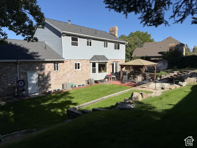Expansive backyard featuring a tiered lawn with built-in water feature