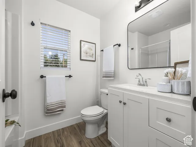 White vanity with a single basin, stainless steel faucet, and white countertop