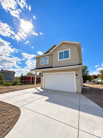 Stucco exterior with white trim windows and a two-car garage