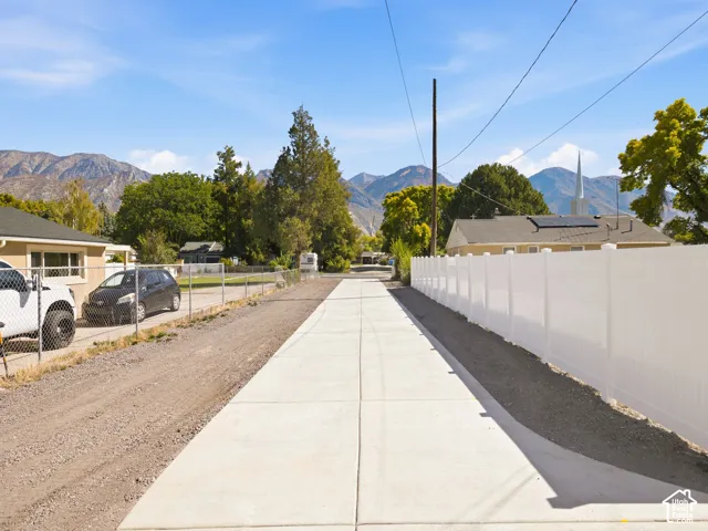 New concrete driveway with a white privacy fence