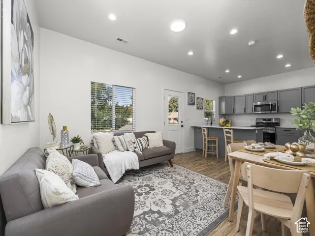 Open-concept living space featuring wood-finish flooring, recessed lighting, and a kitchen with gray cabinetry