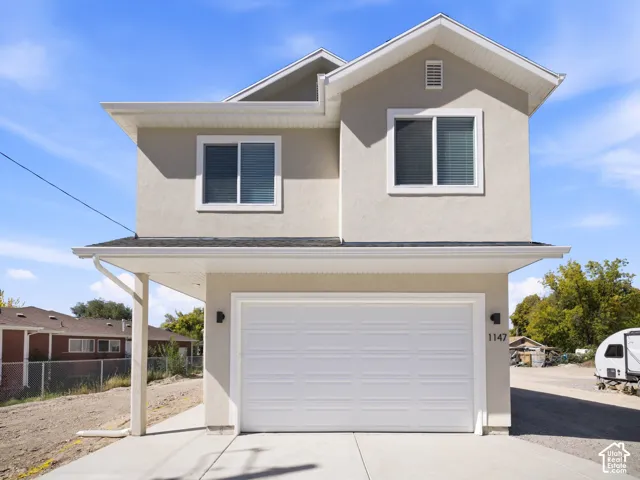 Stucco exterior with a two-story design and a prominent gable roofline
