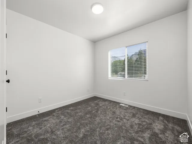 Plush gray carpeting, crisp white walls, and a recessed window with blinds