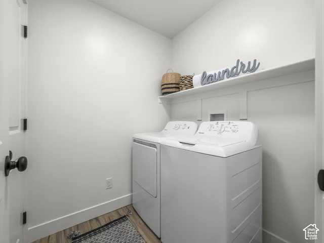 Wood-finish flooring with white baseboards, built-in shelving, and a white door with black hardware
