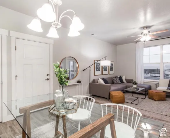 Open-concept living area with wood-finish flooring, white trim, and ample natural light from large windows