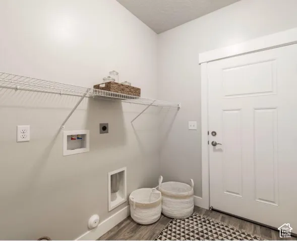 Dedicated laundry space featuring a white wire shelf, utility hookups, and a panel door with brushed nickel hardware