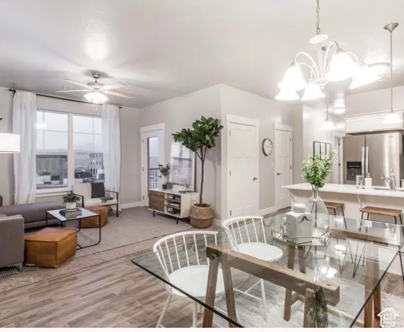 Open-concept living space with wood-finish flooring, a contemporary ceiling fan, and a kitchen featuring stainless steel appliances