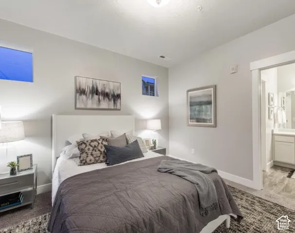 Recessed lighting, large format windows, white trim detailing, and a doorway to an adjoining bathroom featuring a white vanity