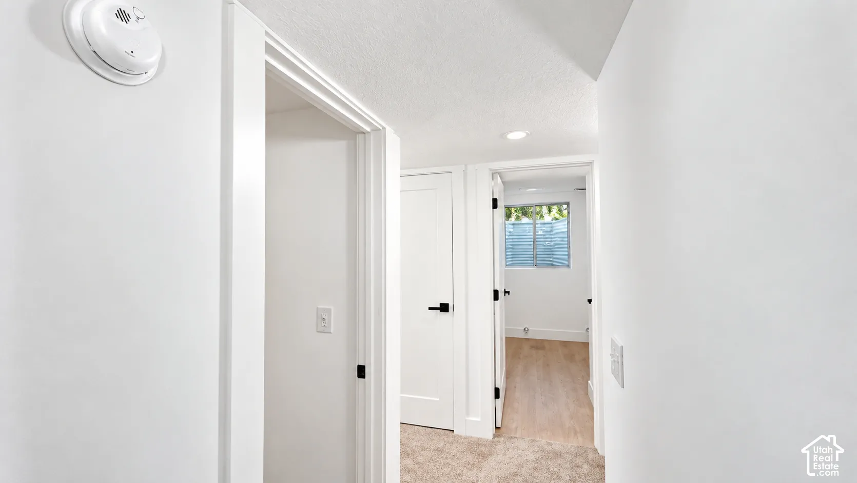 Recessed ceiling lighting, wood-finish flooring, white walls, and white trim