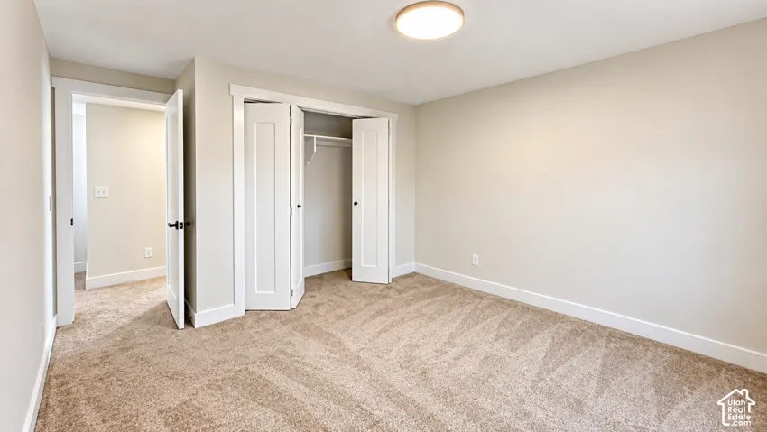 Neutral-toned carpeting, white trim, and a flush-mount ceiling light