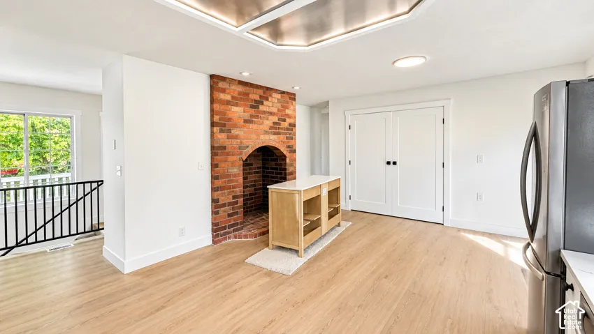 Recessed lighting, wood-finish flooring, and a brick fireplace