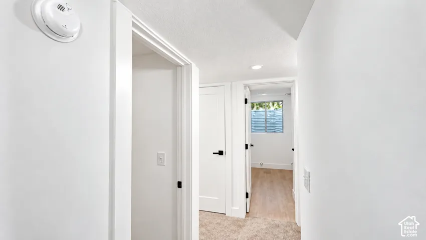 Recessed ceiling lighting, wood-finish flooring, white walls, and white trim