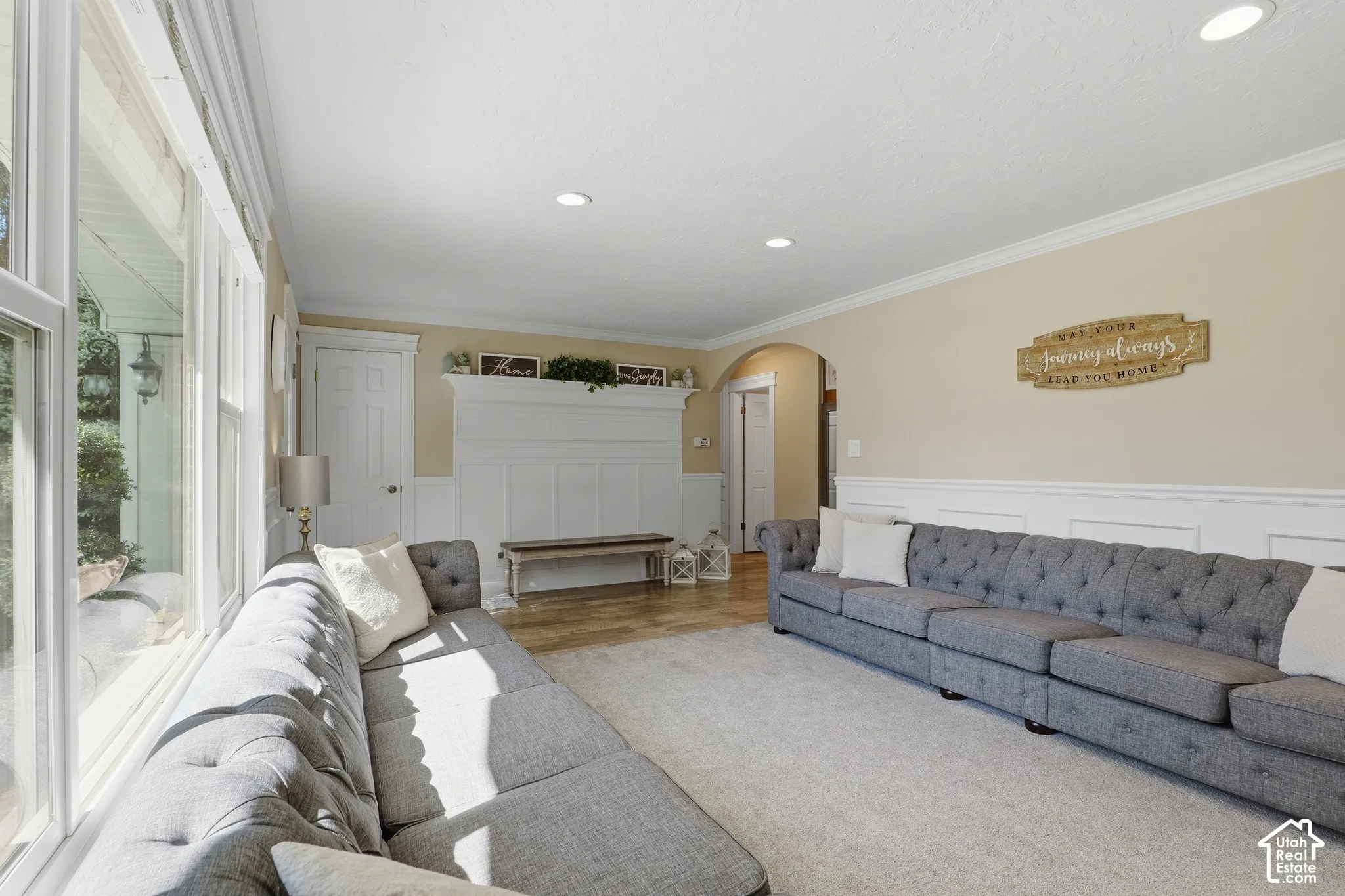 Recessed ceiling lighting, crown molding, wainscoting, wood-finish flooring, and arched doorways