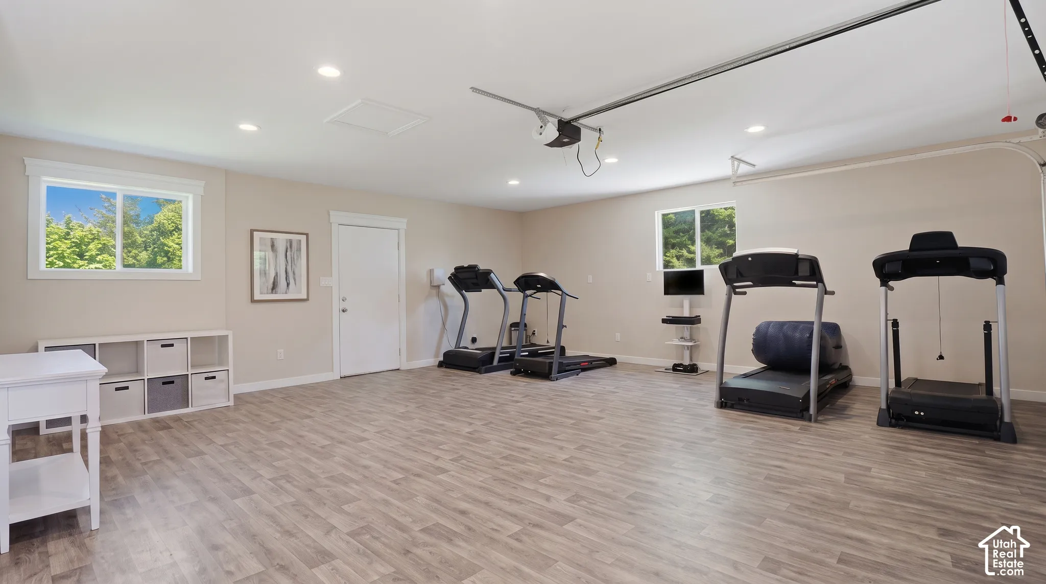 Spacious room featuring wood-finish flooring, recessed lighting, and multiple windows