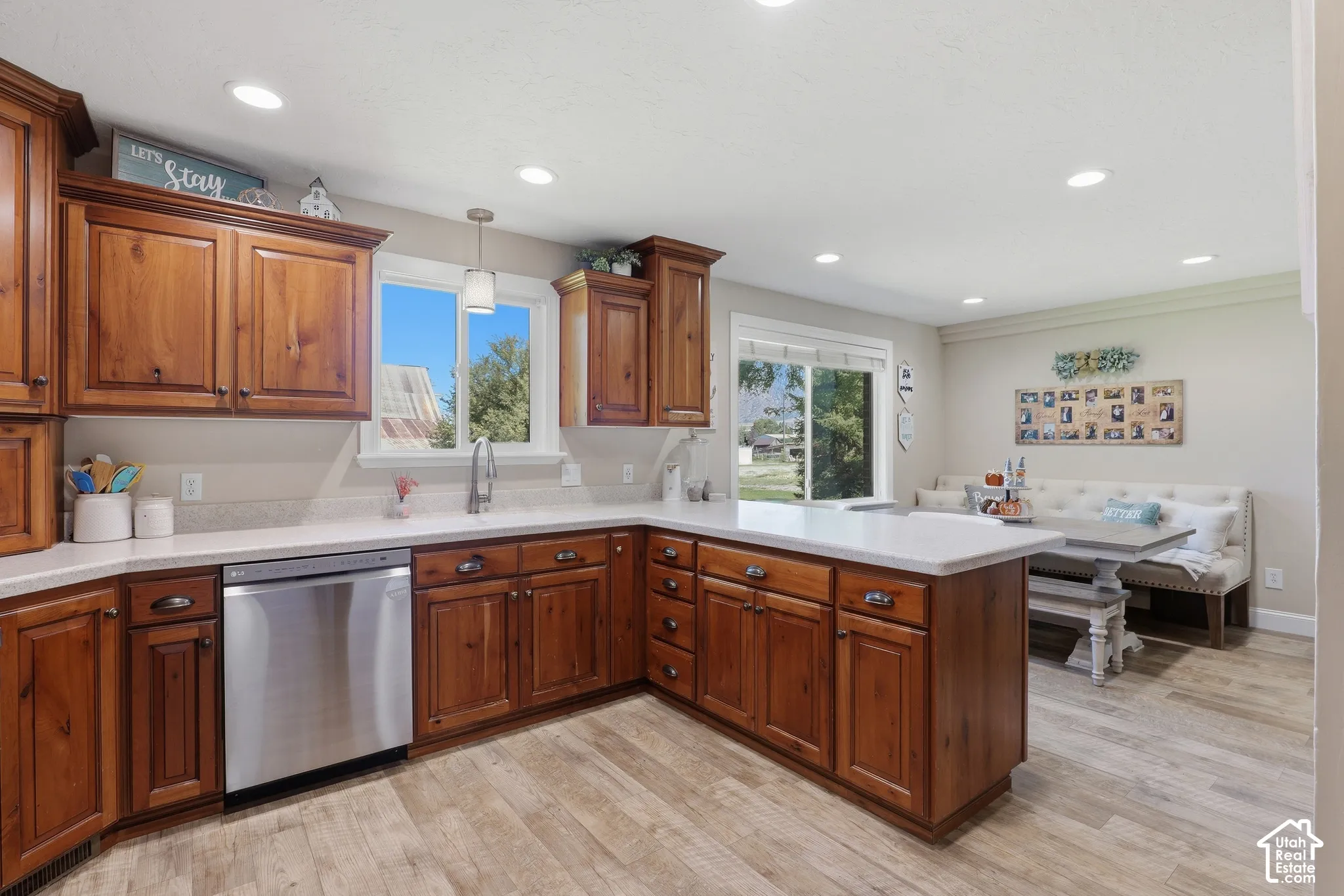 Wood-finish flooring, recessed lighting, and wood cabinetry with stainless steel appliances