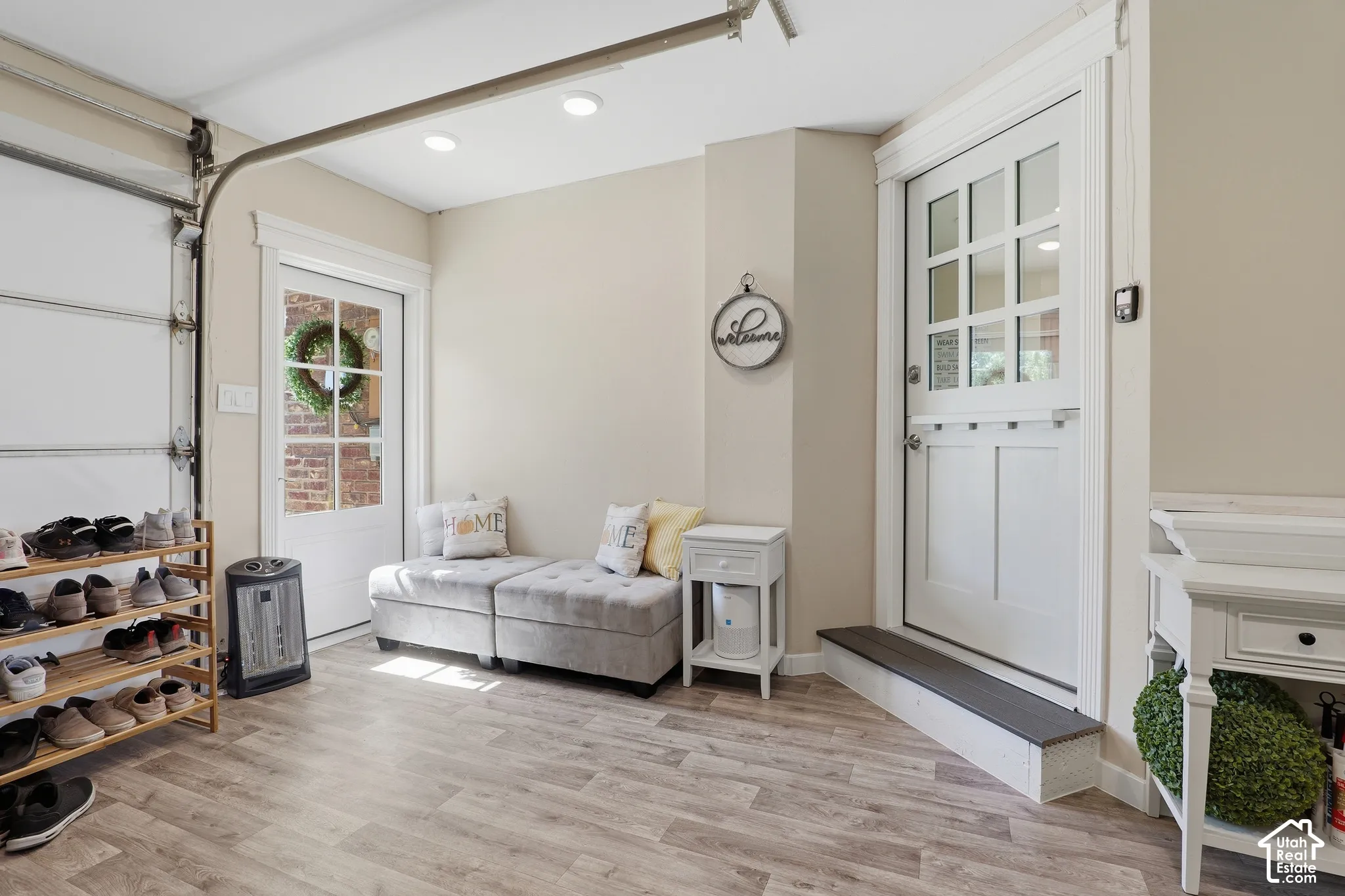 Wood-finish flooring throughout, white interior door with glass panels, recessed ceiling lighting, and a second white interior door with a transom-style upper section