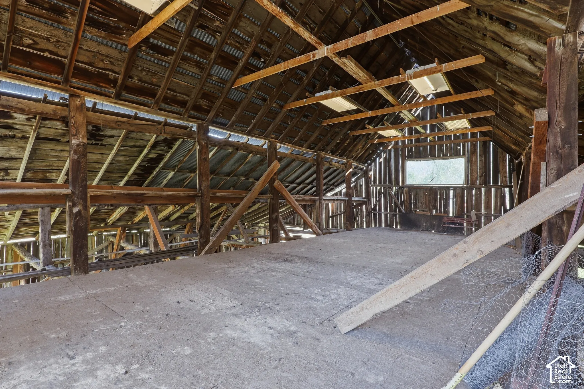 Exposed wood beam construction, corrugated metal roofing, and a single window opening