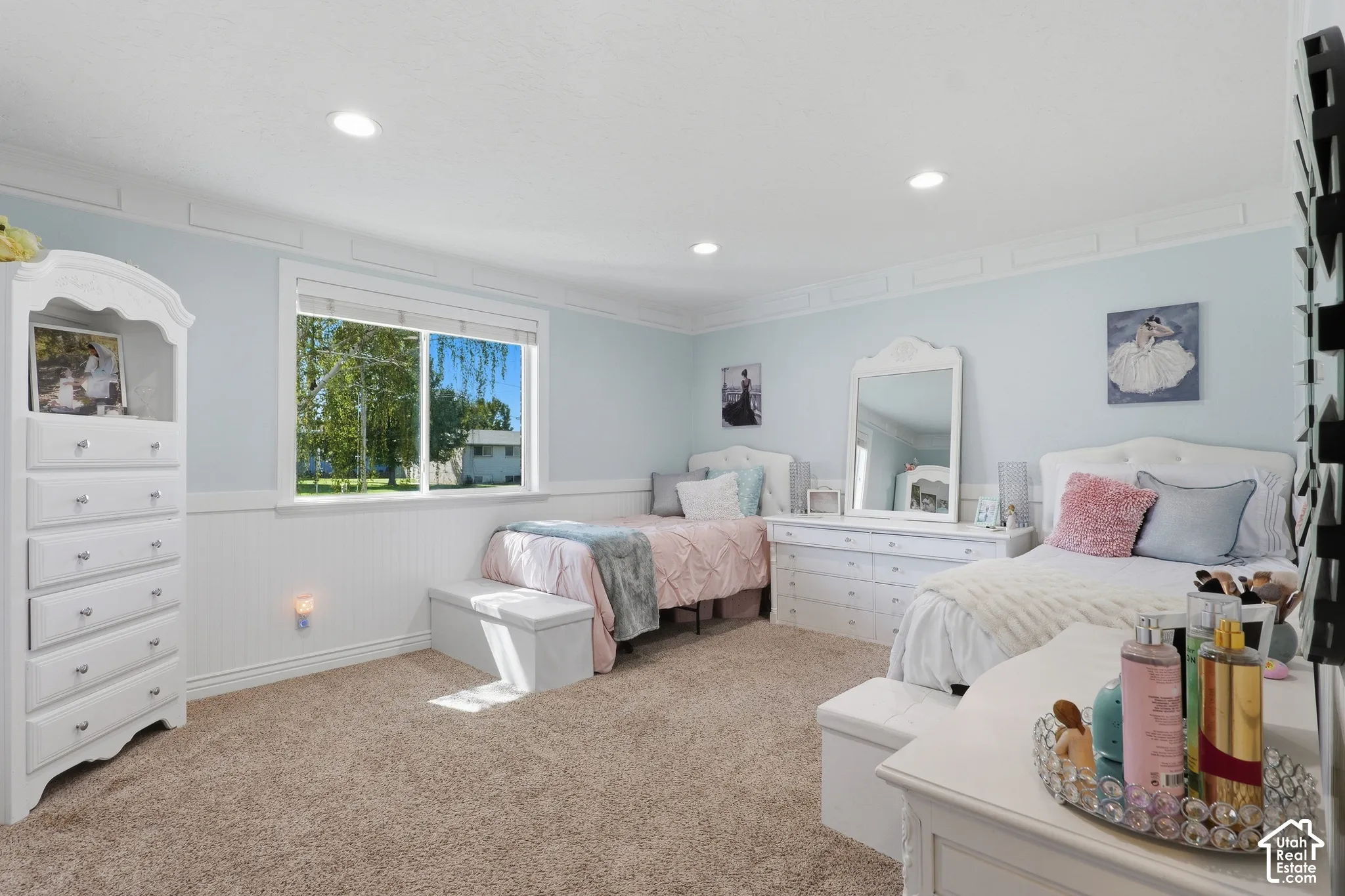 Recessed lighting illuminates a space featuring carpet flooring, horizontal plank wainscoting, and crown molding