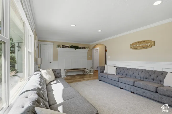 Recessed ceiling lighting, crown molding, wainscoting, wood-finish flooring, and arched doorways