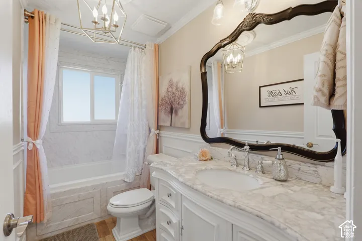 White vanity with an integrated sink and natural stone countertop, framed by a decorative mirror