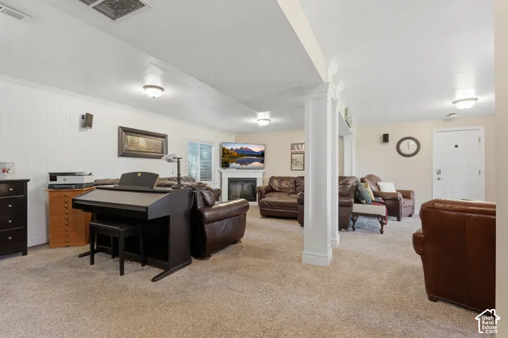 Recessed lighting, fireplace with mantel, sliding glass door, white wainscoting, and carpeted flooring