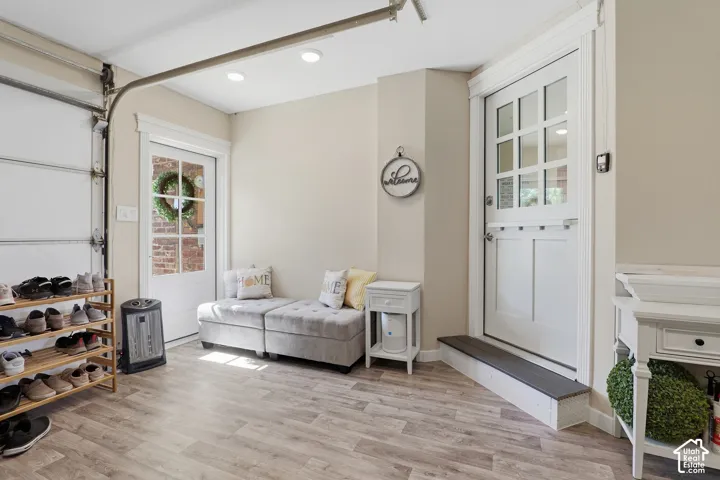 Wood-finish flooring throughout, white interior door with glass panels, recessed ceiling lighting, and a second white interior door with a transom-style upper section