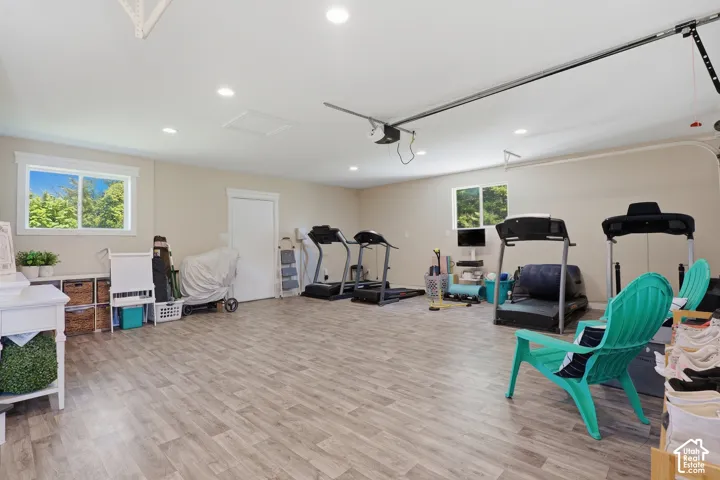 Spacious room featuring wood-finish flooring, recessed lighting, and multiple windows