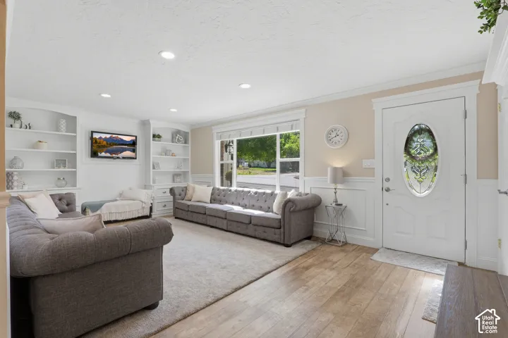 Hardwood-finish flooring leading to a white entry door with an oval-shaped leaded glass insert