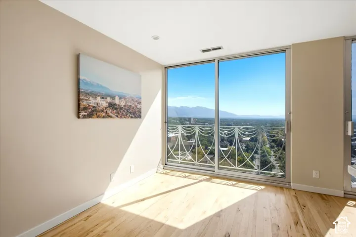 Hardwood flooring, light-colored walls, recessed lighting, and a full-height glass sliding door with a decorative balcony railing.  Dining with a view!