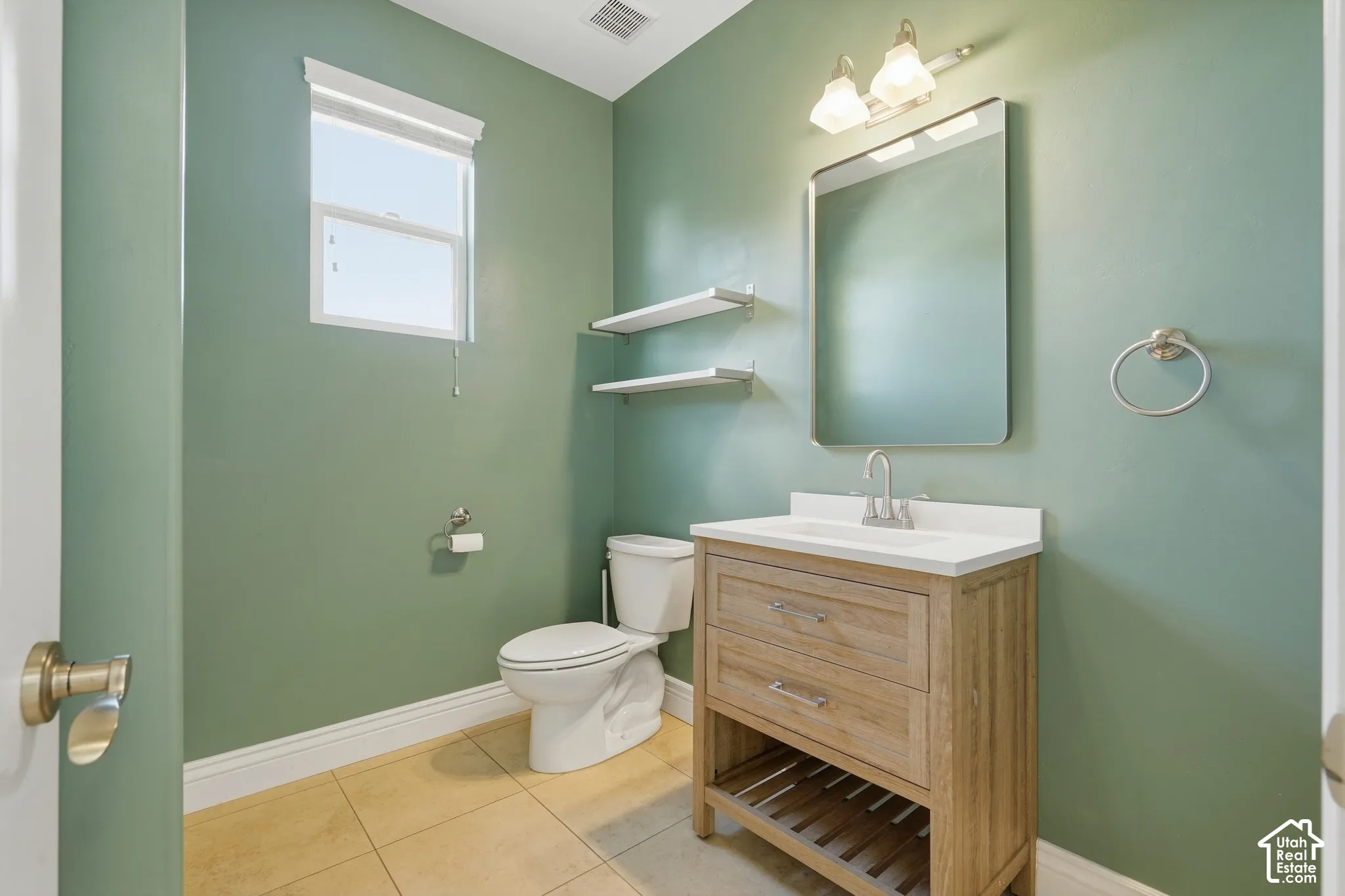 Wood-finish vanity with white countertop, chrome faucet, and rectangular mirror