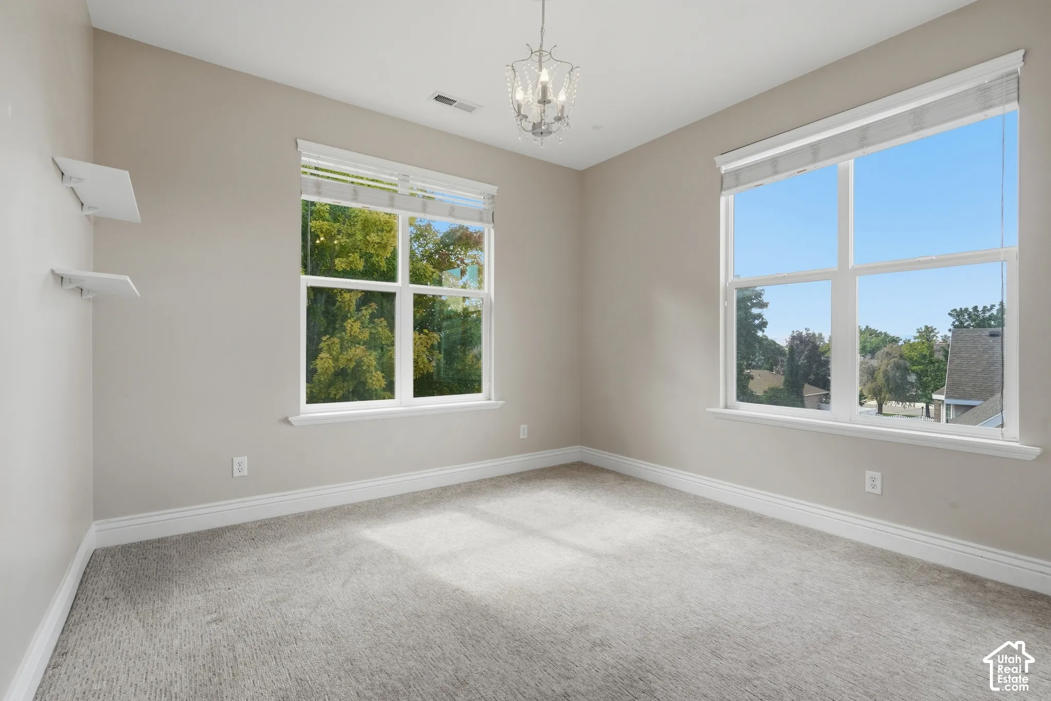 Recessed lighting, large dual pane windows, overhead chandelier, light-toned walls, and carpeted flooring