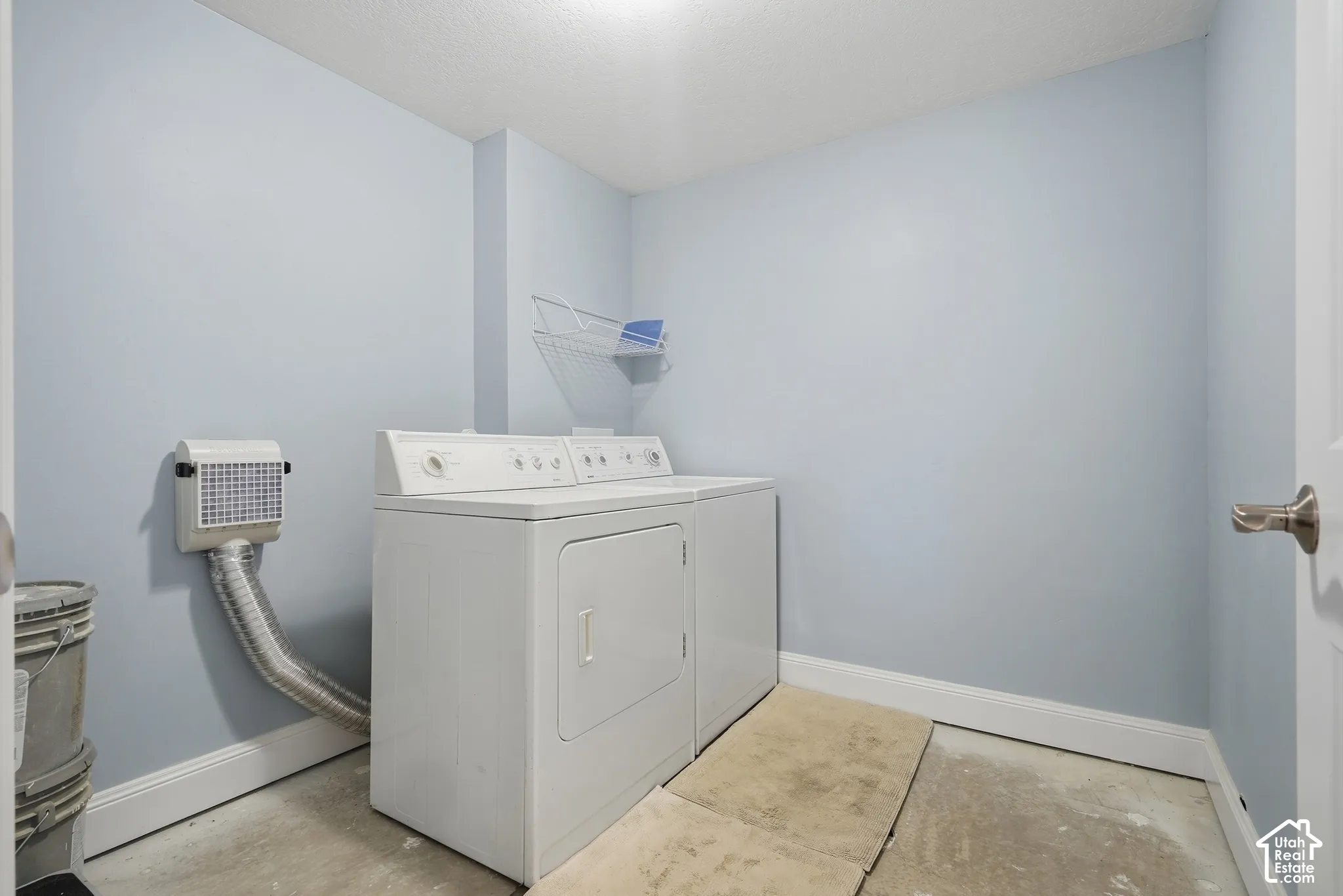 Laundry area with light blue walls and a white baseboard trim
