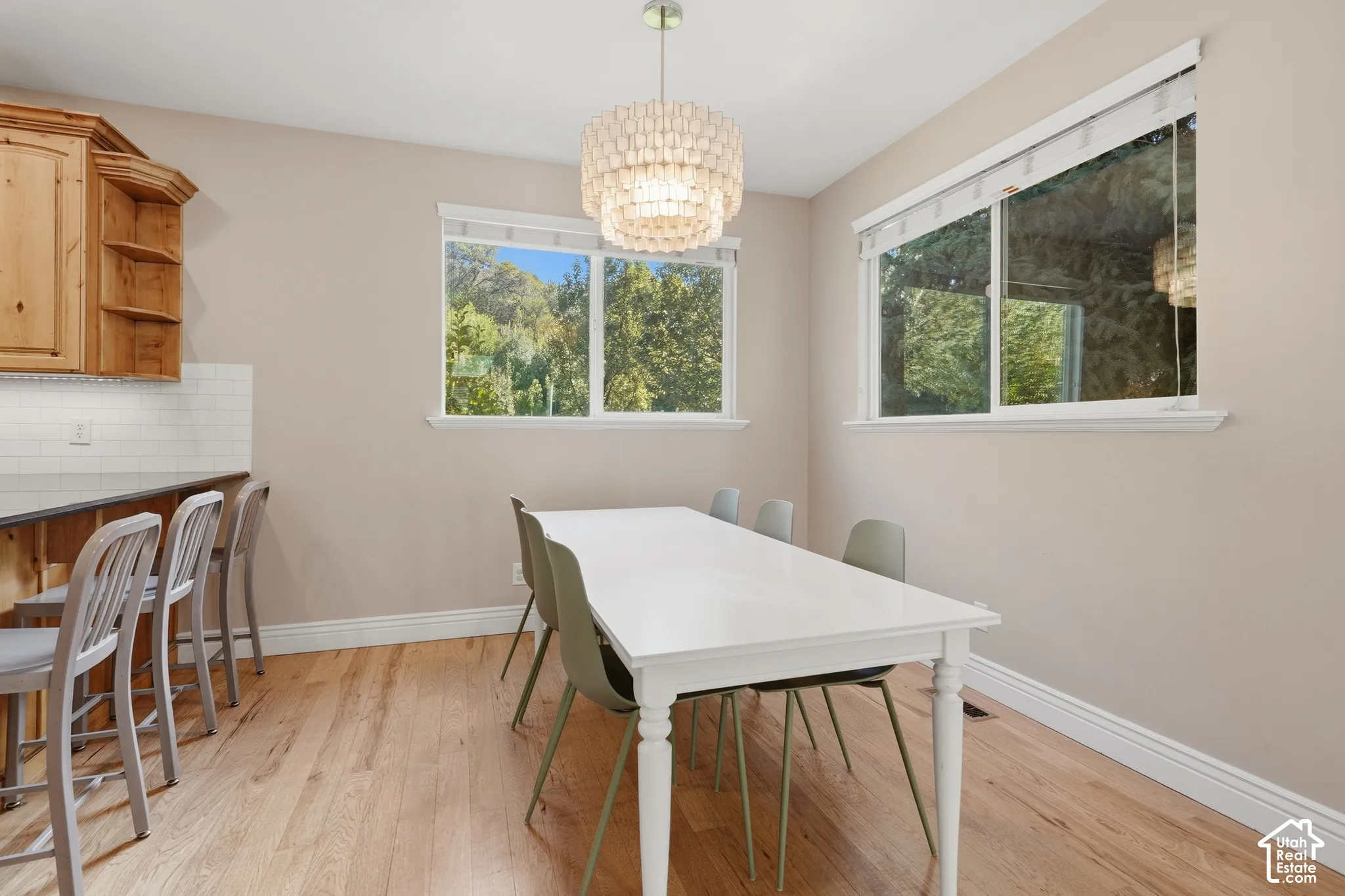 Wood-finish flooring, white trim, recessed lighting, and a tiered chandelier