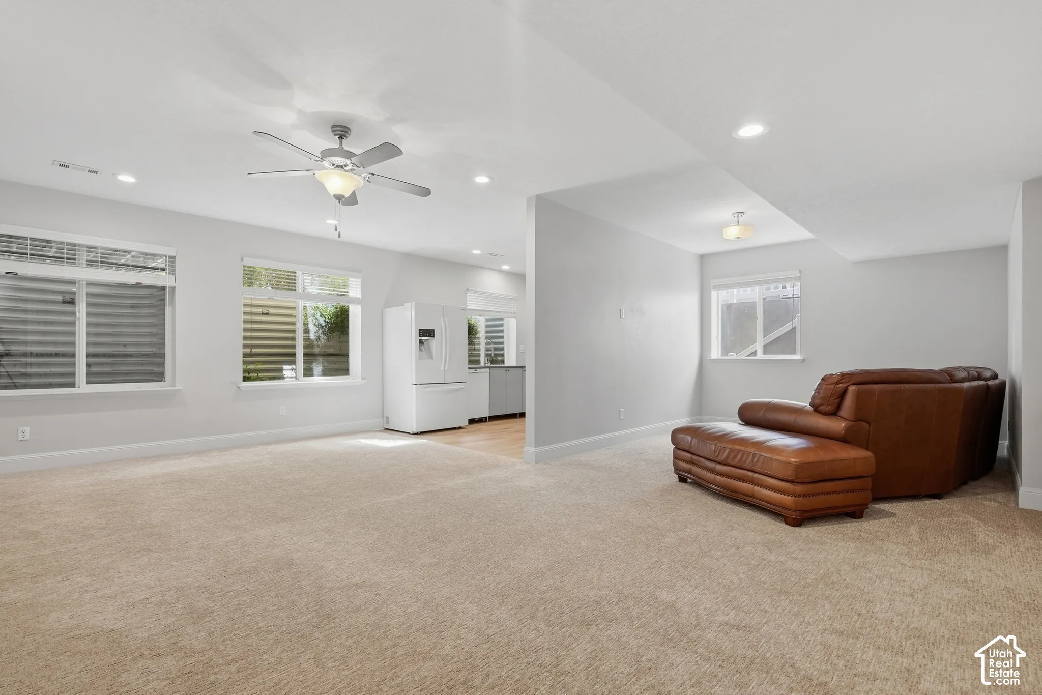Recessed lighting, ceiling fan, white paneled refrigerator, and light wood-finish flooring