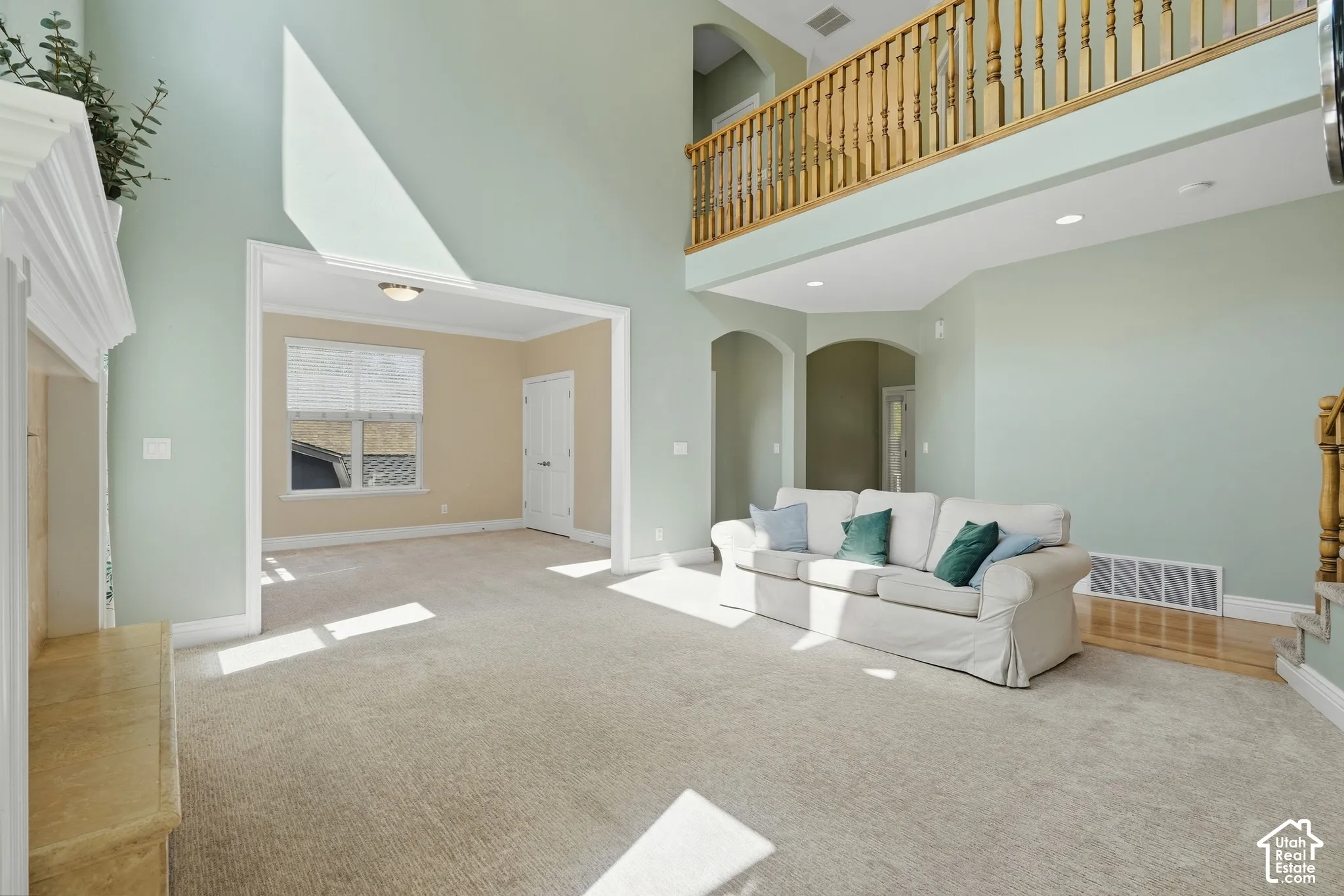 Vaulted ceilings, a second-story open railing, a built-in fireplace, and arched doorways define this living space