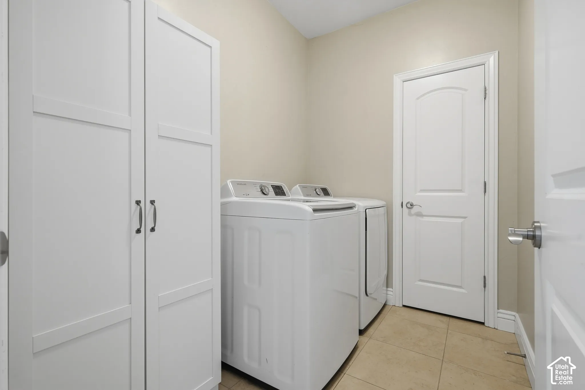 White paneled cabinetry, light neutral wall paint, and tiled flooring