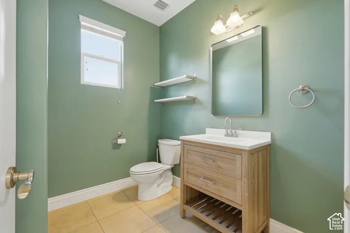 Wood-finish vanity with white countertop, chrome faucet, and rectangular mirror