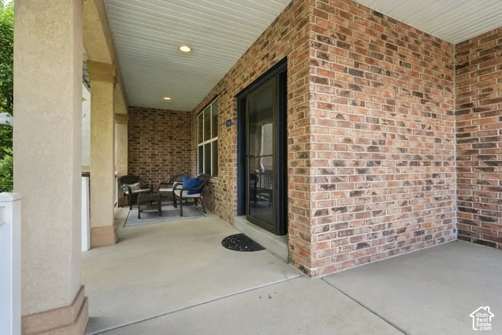 Brick exterior with a covered porch, stucco-finished columns, and a recessed entry