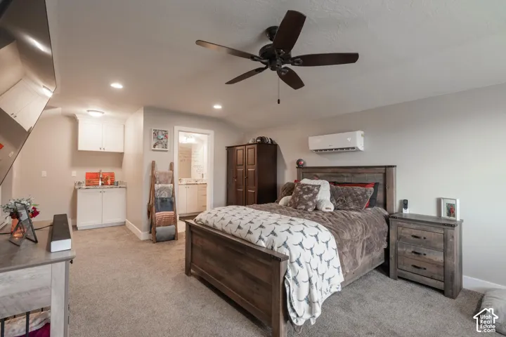 Carpeted flooring, ceiling fan, recessed lighting, white cabinetry, and a built-in wet bar