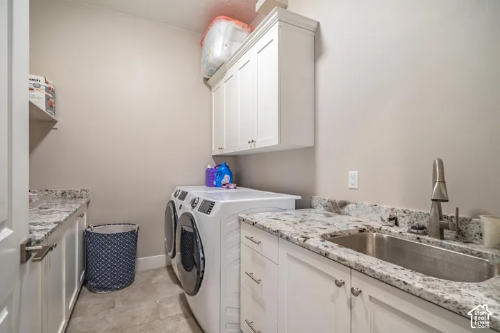 White shaker-style cabinetry, a stainless steel utility sink with a gooseneck faucet, light-toned granite-style countertops, and tiled flooring