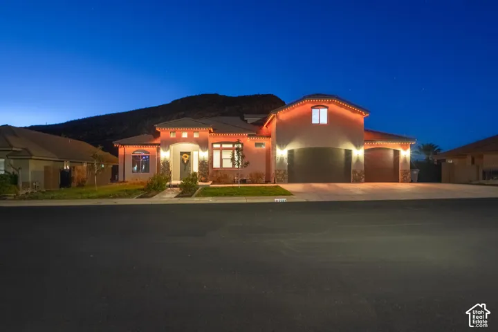 Stucco exterior with a tiled roof, multi-car garage, and a concrete driveway