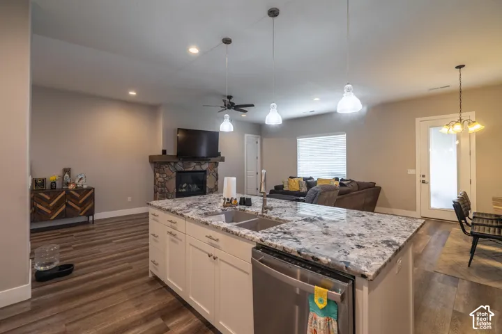 Kitchen island with integrated sink, white cabinetry, and granite countertop