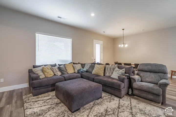 Spacious living area featuring wood-finish flooring, neutral wall tones, and recessed lighting