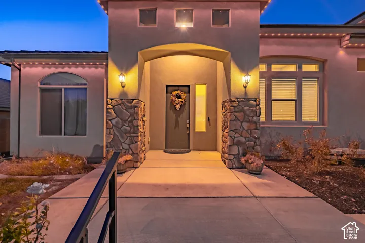 Stucco exterior featuring an arched entry, stone veneer accents, and arched and rectangular windows