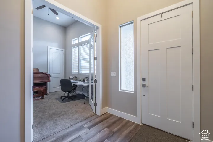 Entryway with wood-finish flooring, a white paneled entry door, and a frosted glass sidelight