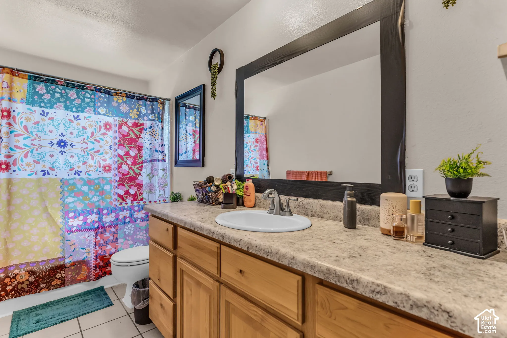 Wood-finish vanity with panel doors and drawers, featuring a light-colored countertop and an integrated sink