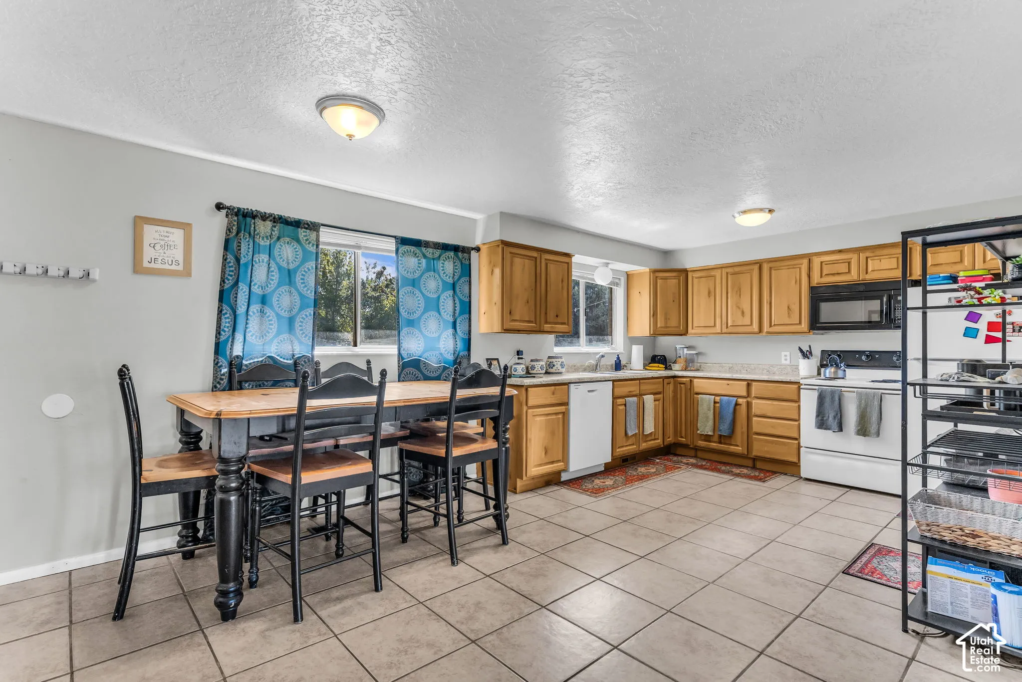 Tile flooring throughout, natural wood-finish cabinetry, built-in microwave, and recessed lighting