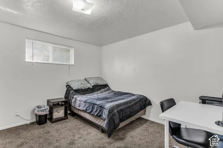 Carpeted flooring, white painted walls, and a window with blinds