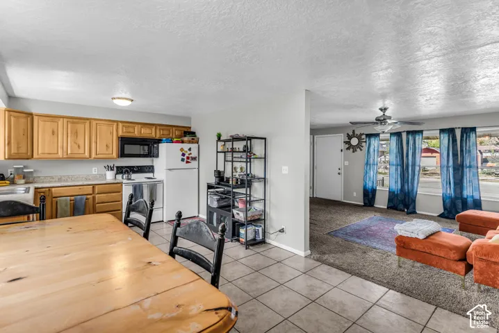 Kitchen featuring wood cabinetry, laminate countertops, and tile flooring