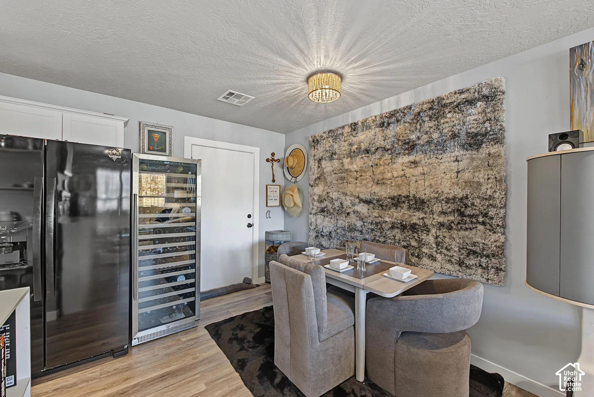 Stainless steel wine cooler, wood-finish flooring, white cabinetry, and a contemporary ceiling fixture